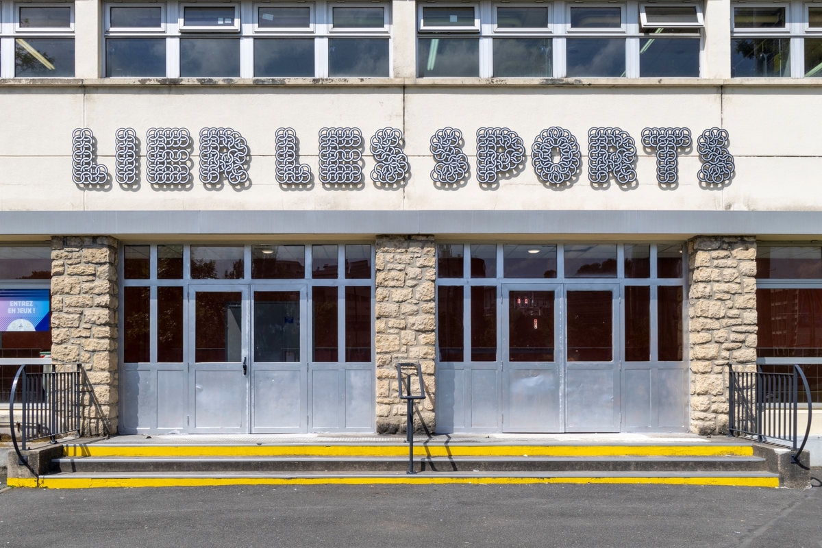 Façade du Centre sportif Jules Noël avec l'inscription "Lier les sports"
