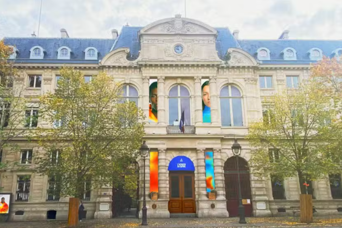 Façade de l'ex-mairie du 4e arrondissement, de type haussmannien, avec de grandes bannières de couleur