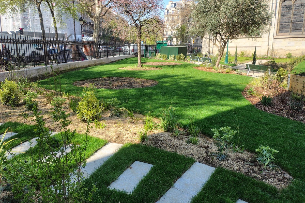 Un cheminement en pavés enherbés devant la grande pelouse