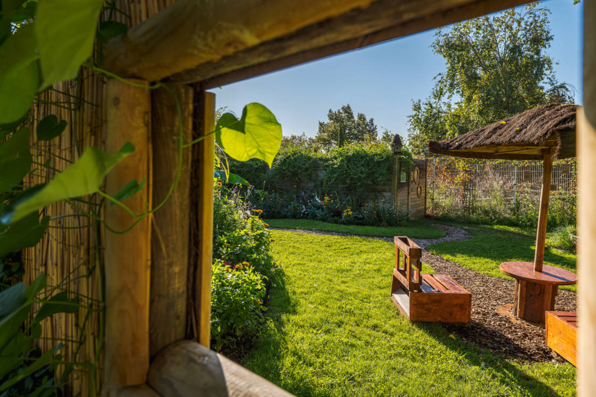 vue sur le jardin depuis un cadre en bois - Créations végétales réalisées pour le concours 2026 Le Défi des jardiniers