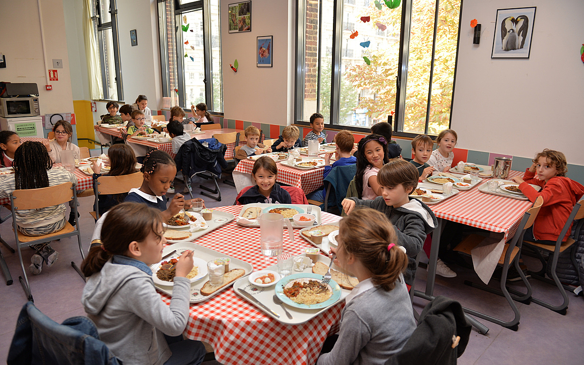 Réfectoire scolaire avec des enfants qui déjeunent école située au 34 faubourg St Denis Paris 10e