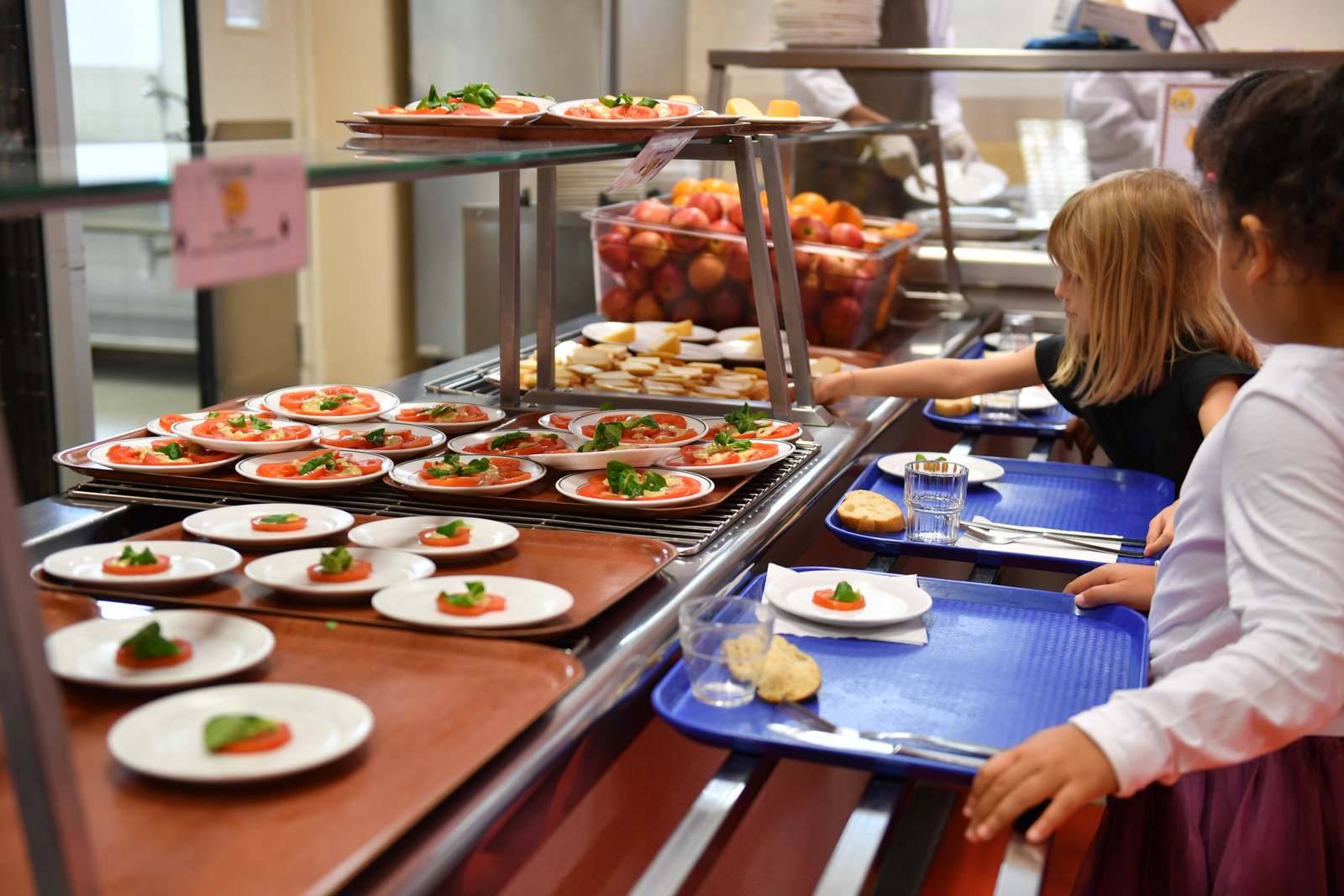 Réfectoire scolaire avec des enfants qui choisissent leurs portions