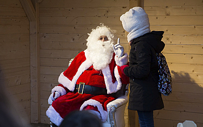 le père noël et un enfant dans une cabane