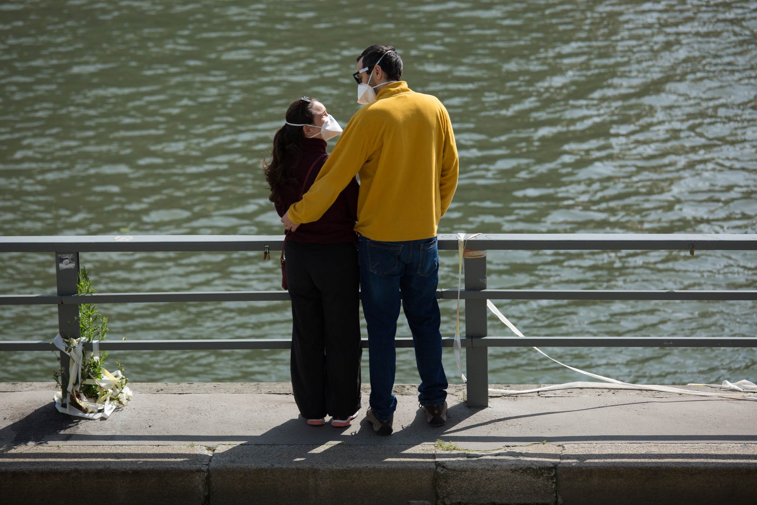 Couple portant un masque sur les Rives de Seine au soleil