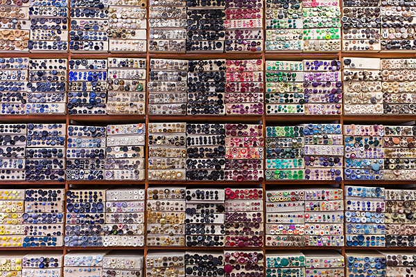 Rubans, fils, perles, laine, plumes, aiguilles, strass
boucles et bien entendu boutons, recouvrent les murs du sol au plafond.