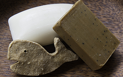 Trois savons fabriqués maison dont un en forme de baleine.