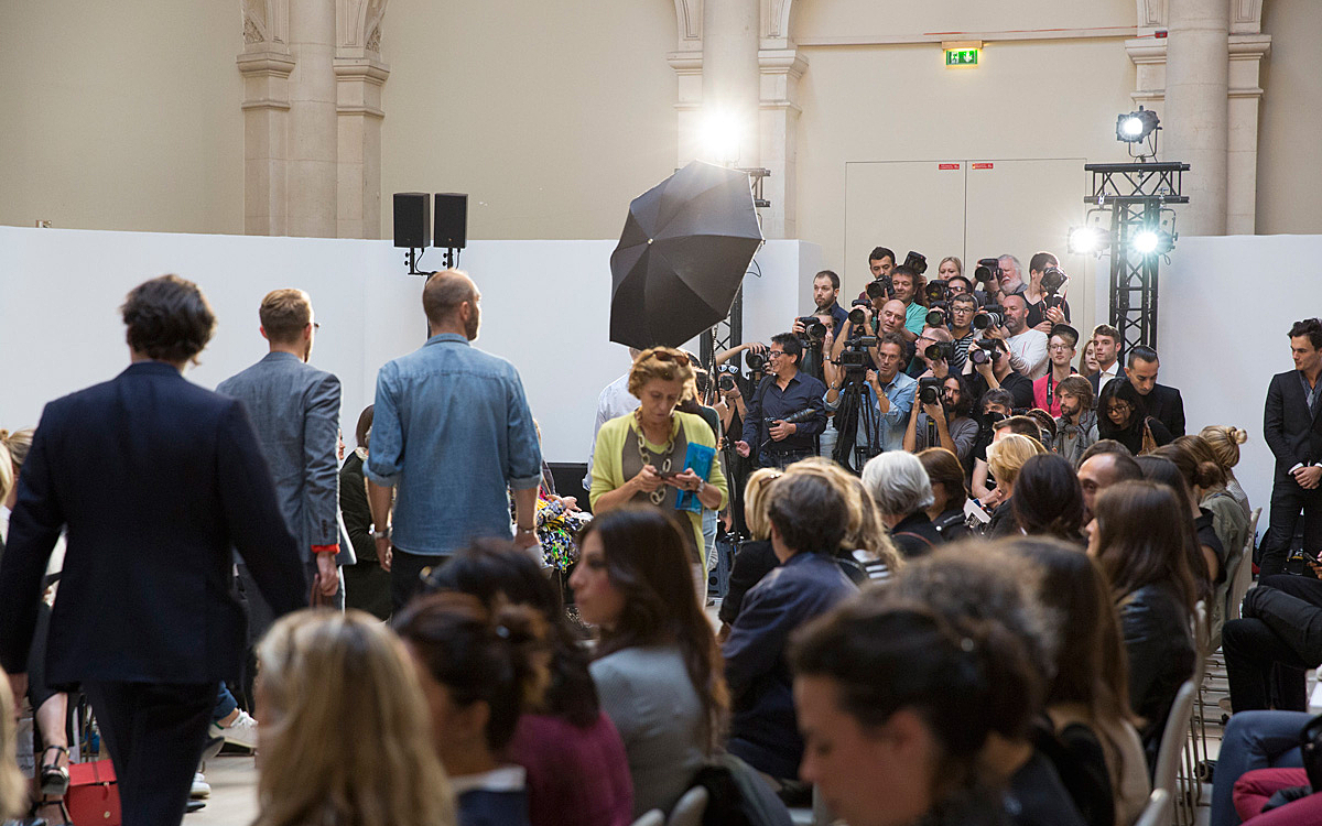 Public et photographes se préparent pour le défilé.