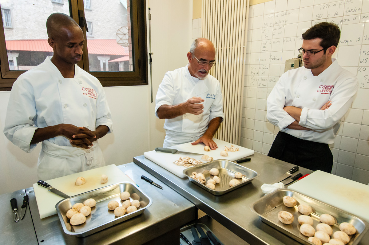 Cuisiniers apprentis en train de préparer des champignons avec leur chef.