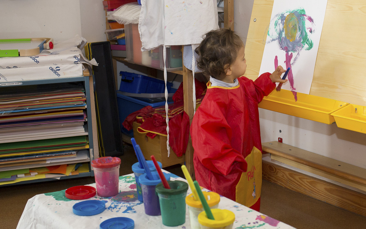 Enfant entrain de peindre dans un atelier peinture à la crèche