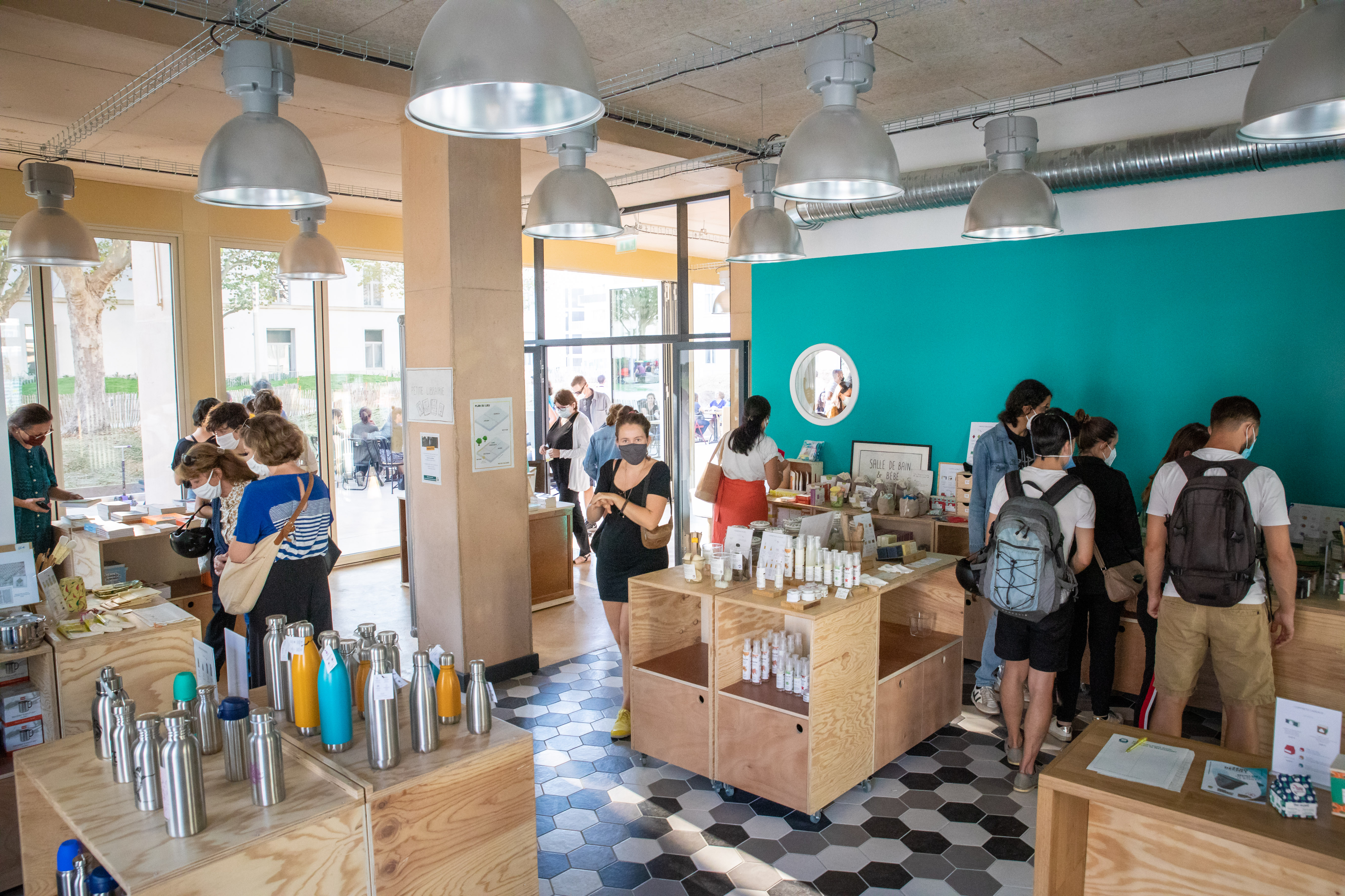 Intérieur de la boutique de la Maison du Zéro Déchet, présentant tous les produits durables, avec quelques visiteurs et visiteuses