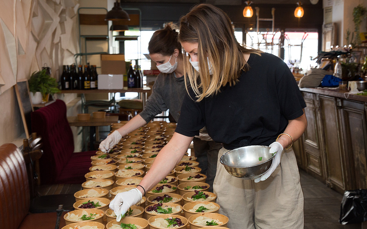 De jeunes femmes préparent des repas pour le personnel soignant.