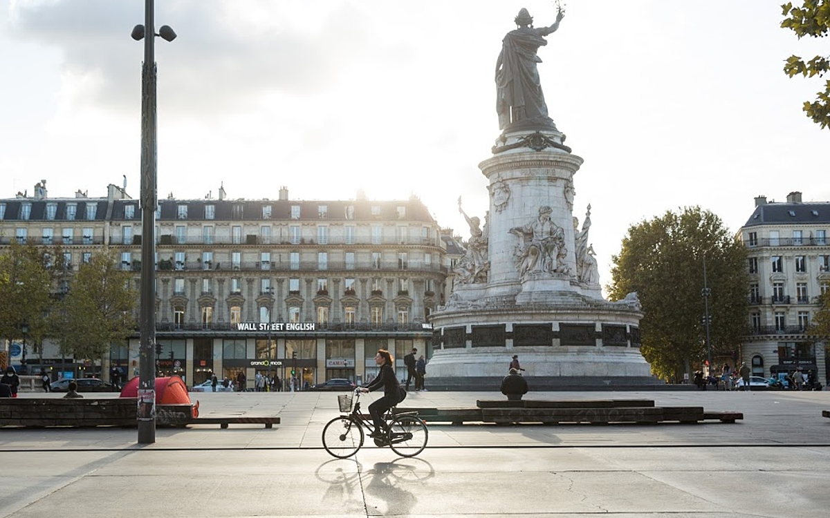 Une cycliste passe sur le Place de la République.