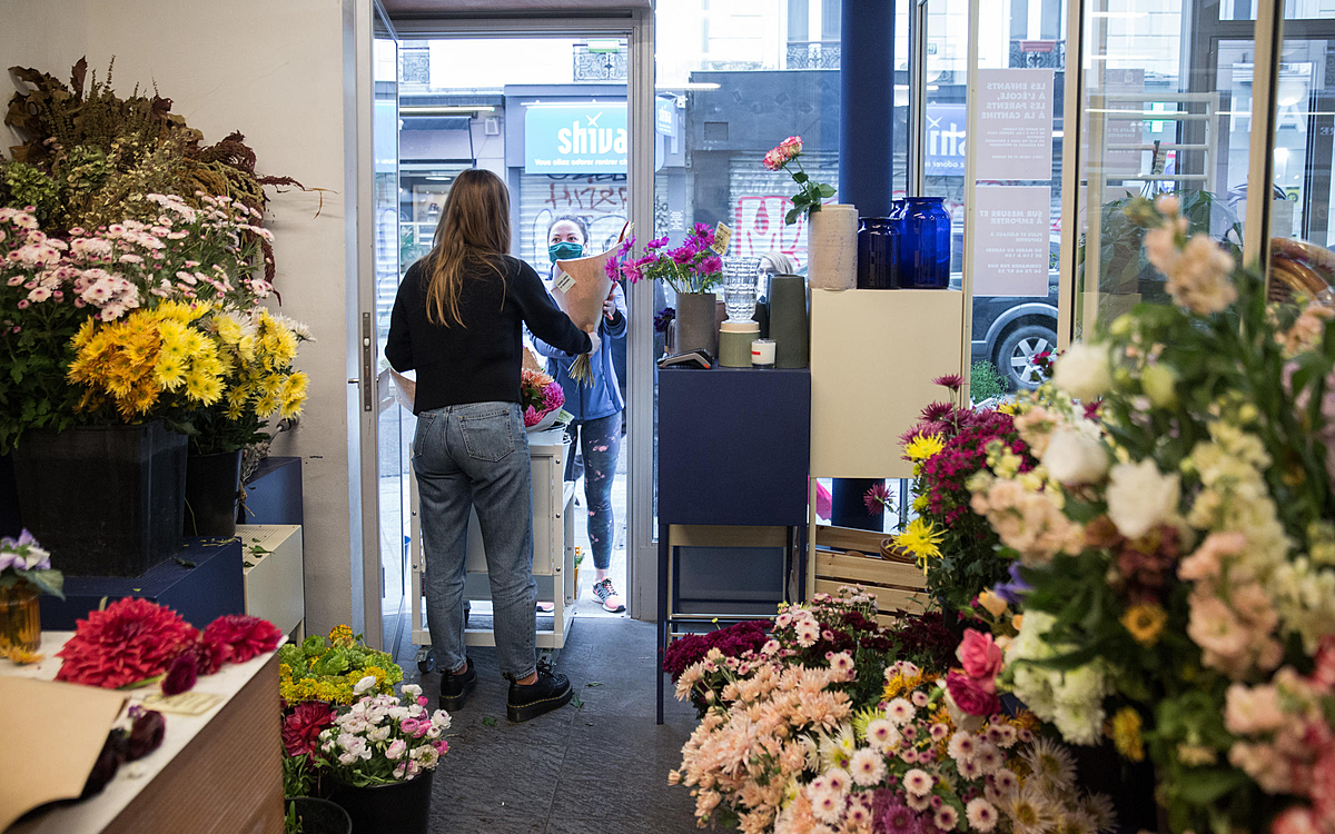 Une fleuriste donne un bouquet à sa cliente.
