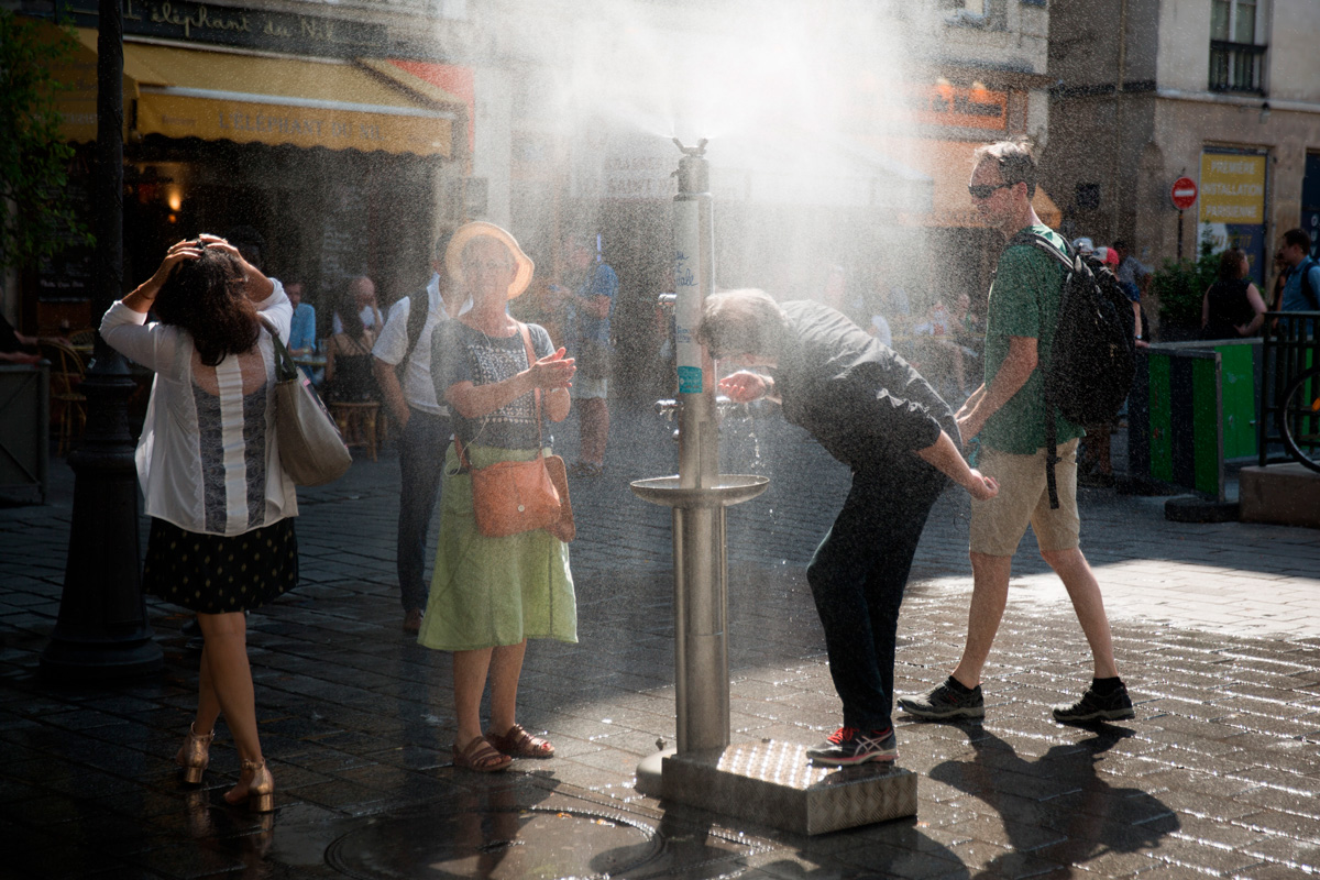 Une personne boit de l'eau à une fontaine.