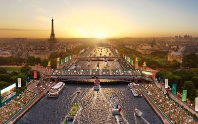 Un visuel de la cérémonie d'ouverture sur la Seine devant un soleil couchant.