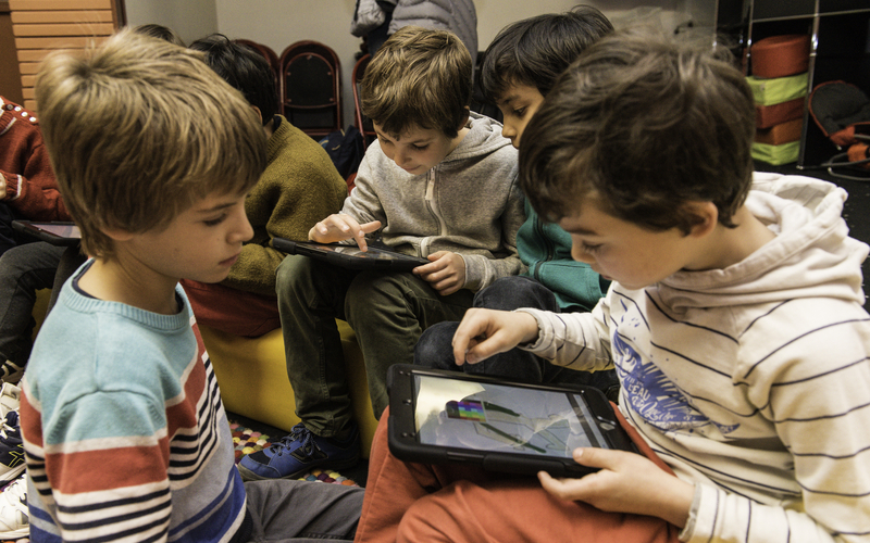 Enfants regardant une tablette à la médiathèque Marguerite Yourcenar