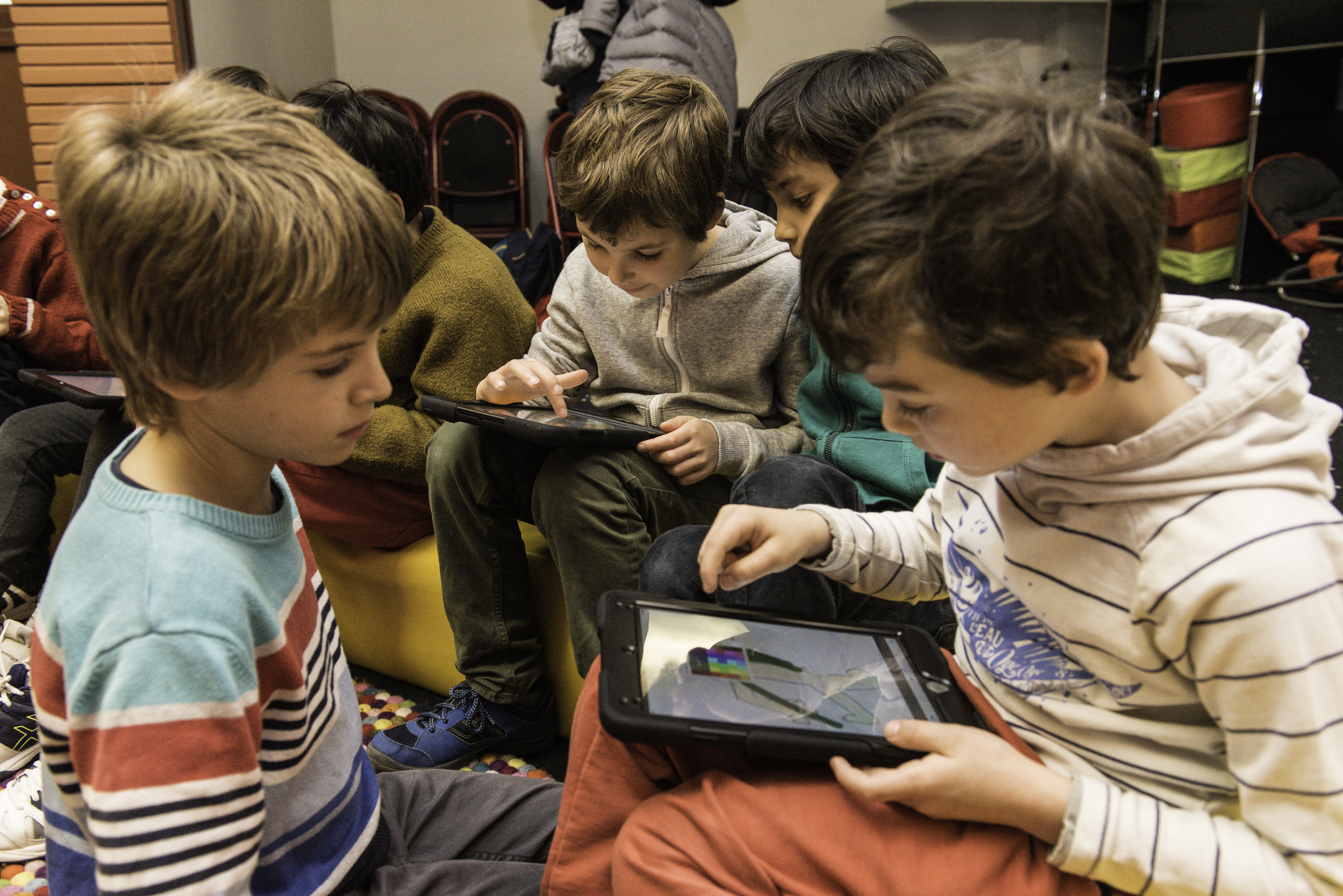 Enfants regardant une tablette à la médiathèque Marguerite Yourcenar