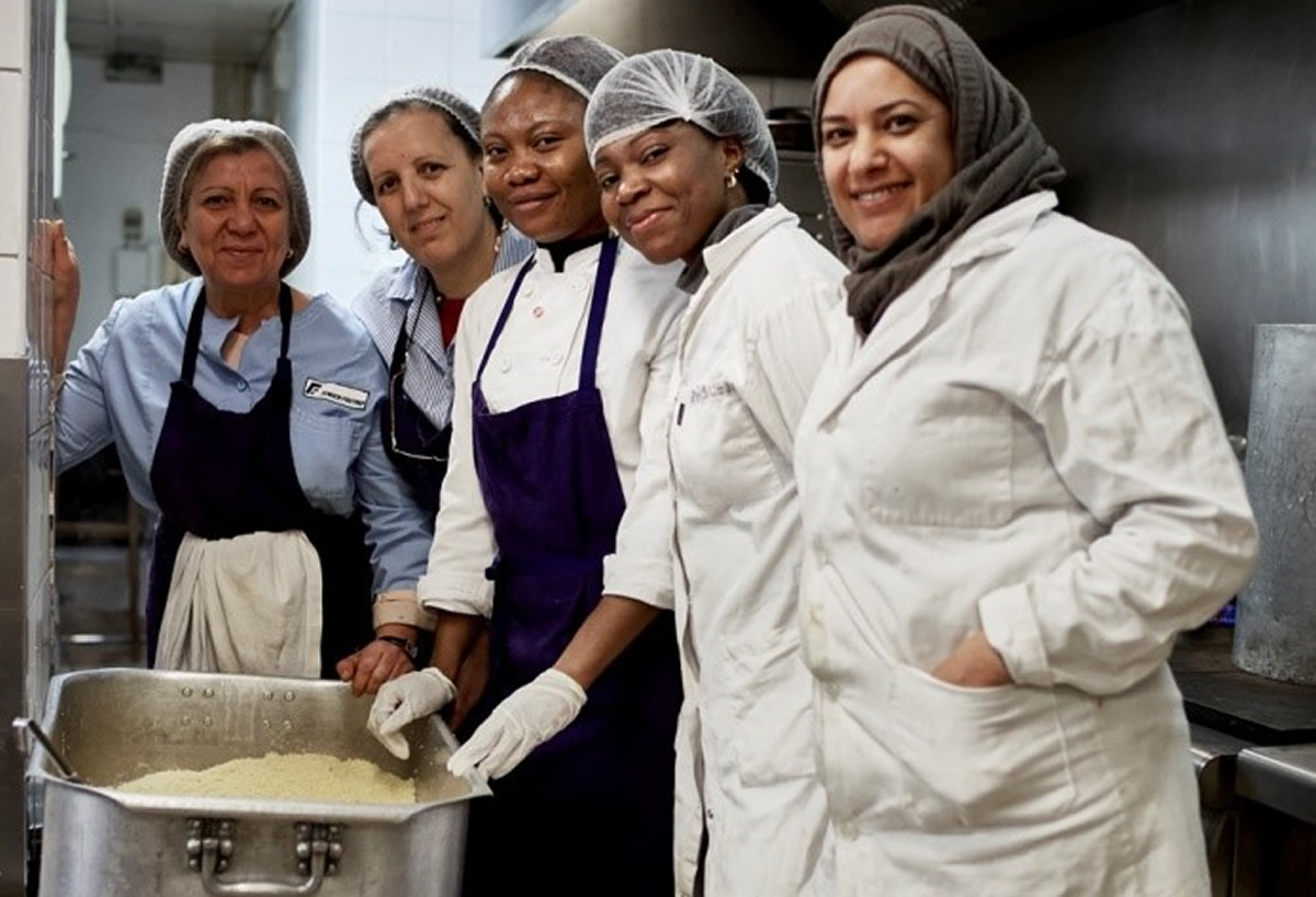 Les équipes de cuisine, cheffes encadrantes et salariées en insertion cuisinant toutes ensemble les repas pour les distributions du jour.