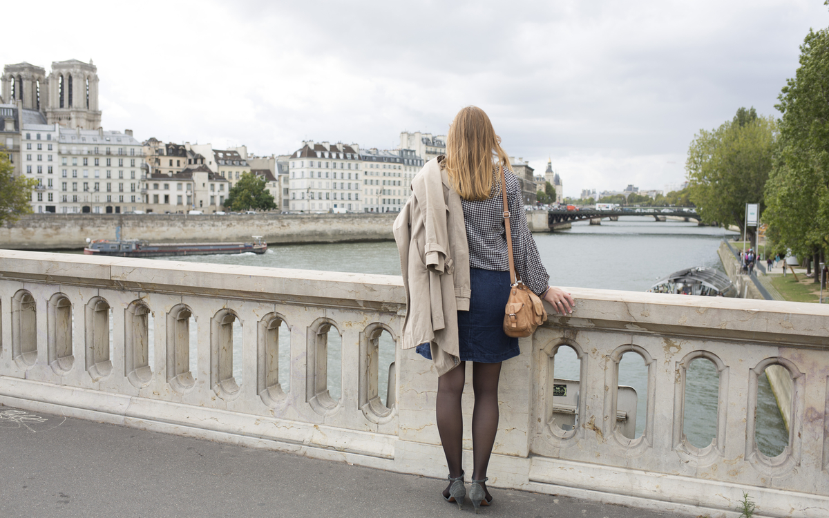 Une femme sur le pont Louis-Philippe face à Notre-Dame de Paris