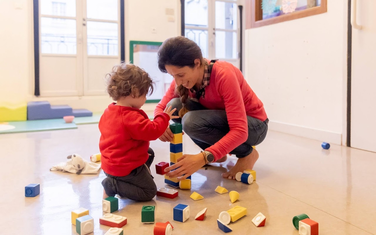 Maman jouant avec son enfant dans une crèche