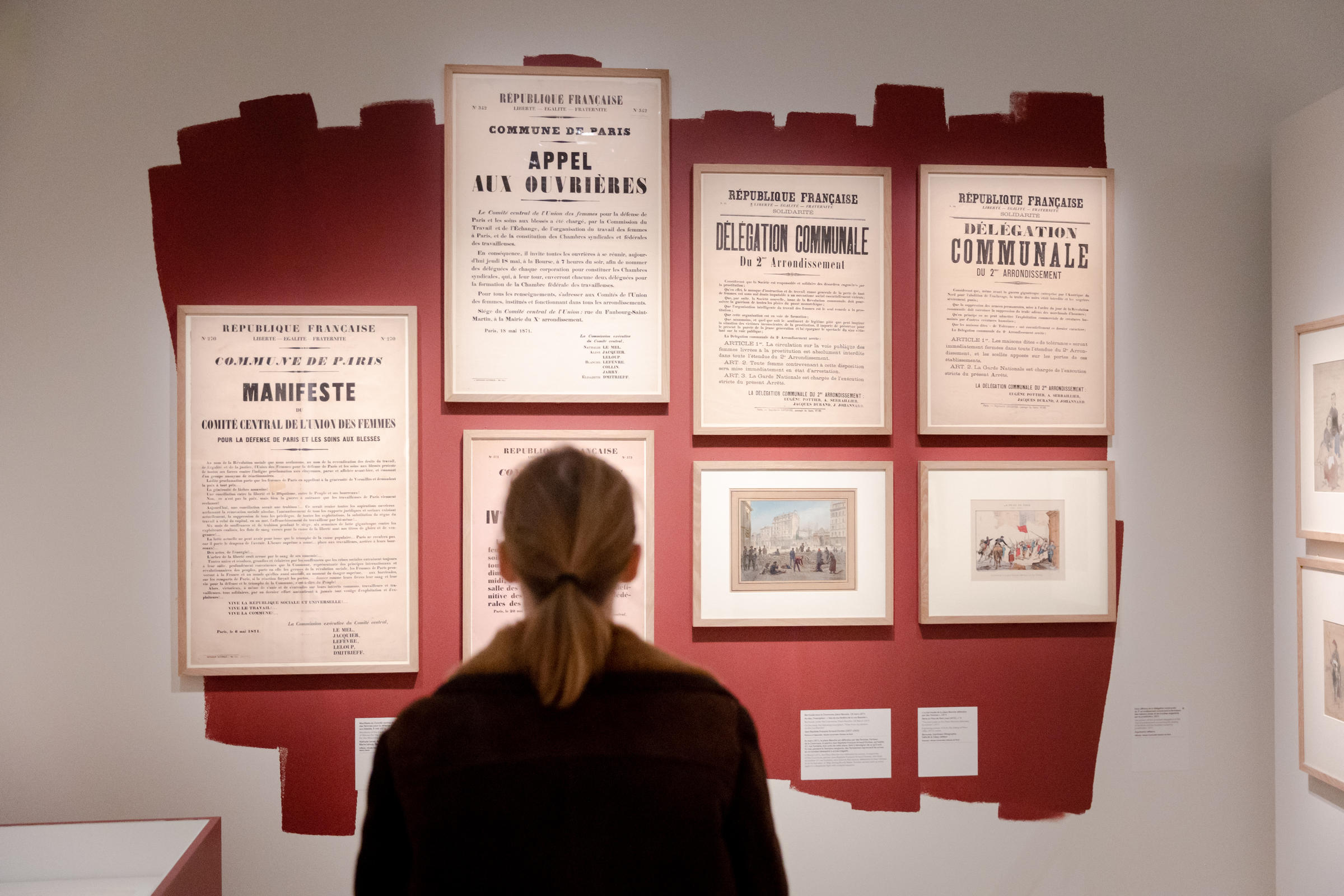 Une femme regarde différents tracts rassemblés dans l'exposition « Parisiennes Citoyennes » au musée Carnavalet - Histoire de Paris