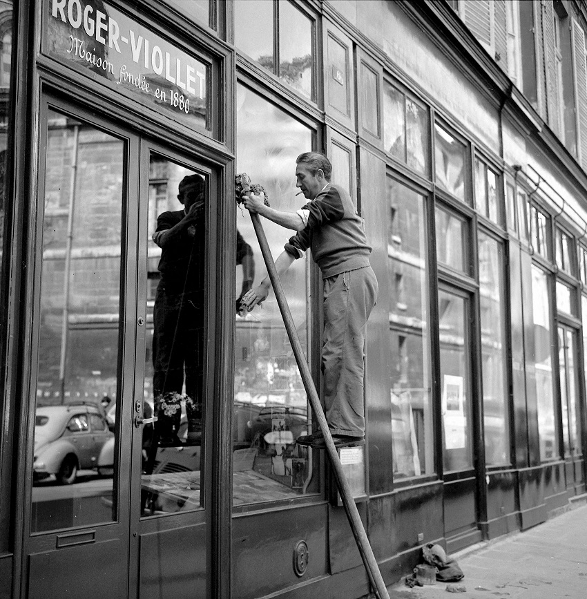 Laveur de carreaux à l'agence photographique Roger-Viollet, 6 rue de Seine. Paris (6e), mars 1960.