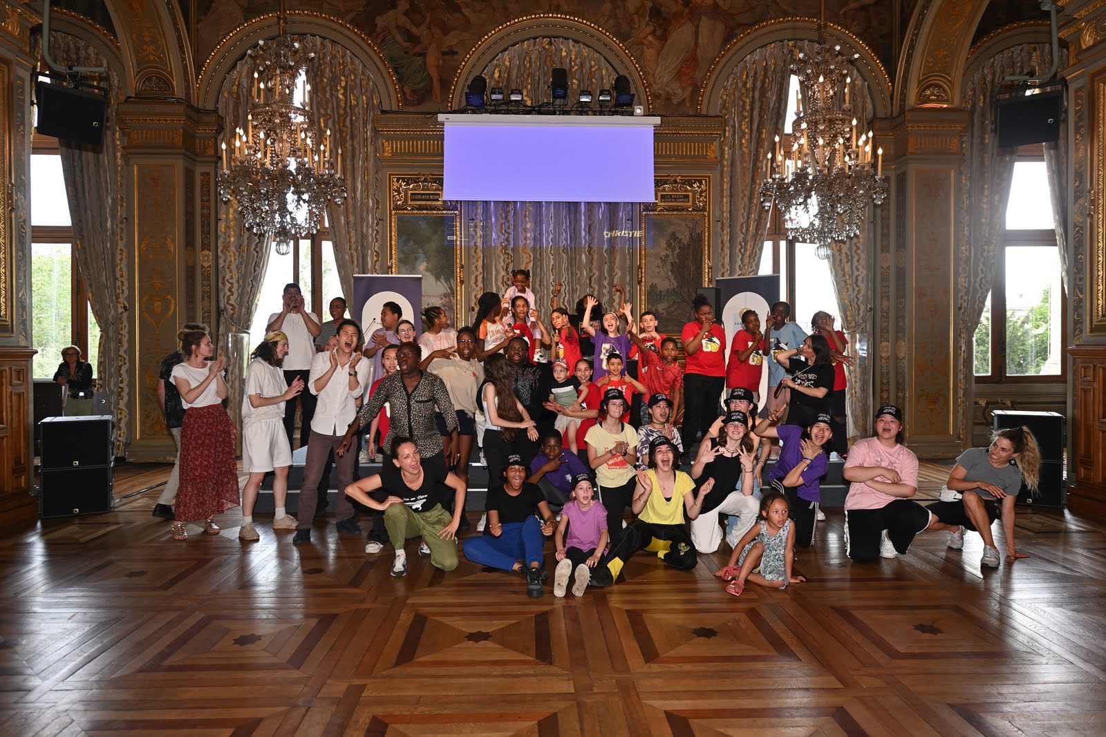 Des collégiens posent en groupe avec les encadrants après leur spectacle de Break et de danse Hip-Hop à l'Hôtel de Ville devant leurs familles