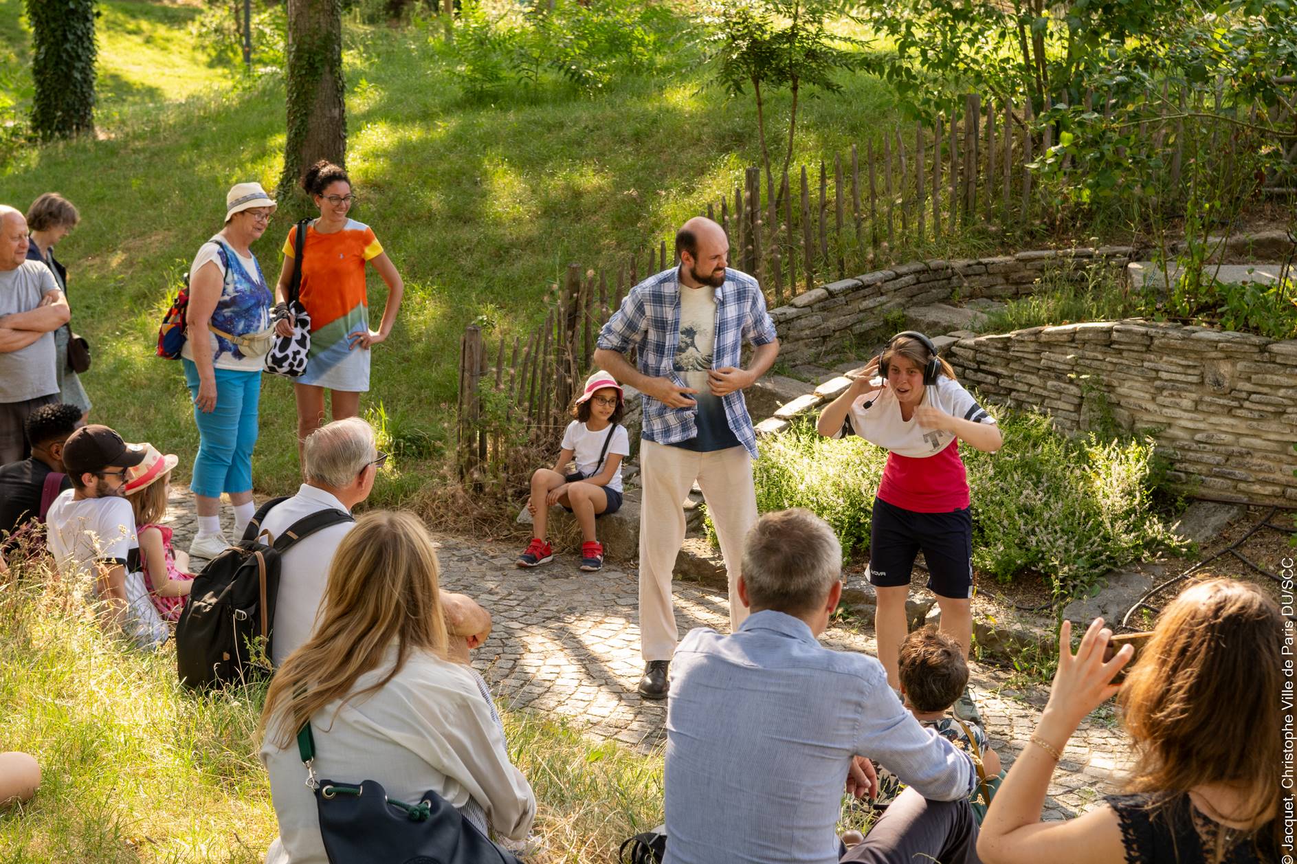 Photo de comédiens jouant dans le parc entouré d'un public