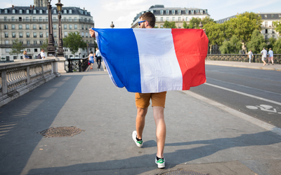 Supporter marchant avec son drapeau français dans les rues de Paris.