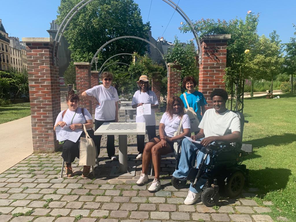 Group of people posing in a park, one of them in a wheelchair