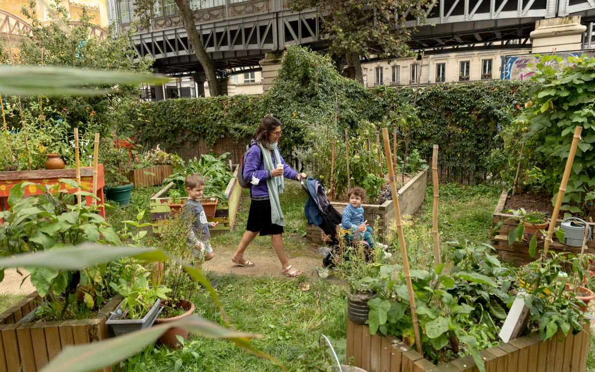 Une maman se promenant avec ses deux enfants dans un jardin lors de la fête des jardins, dans le 19ème arrondissement