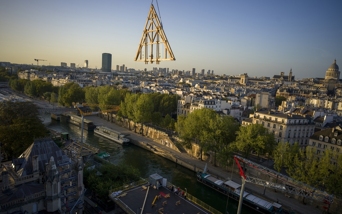 Dans le ciel de Paris, le montage de la charpente de la nef a commencé, grâce au travail des charpentiers et des grutiers