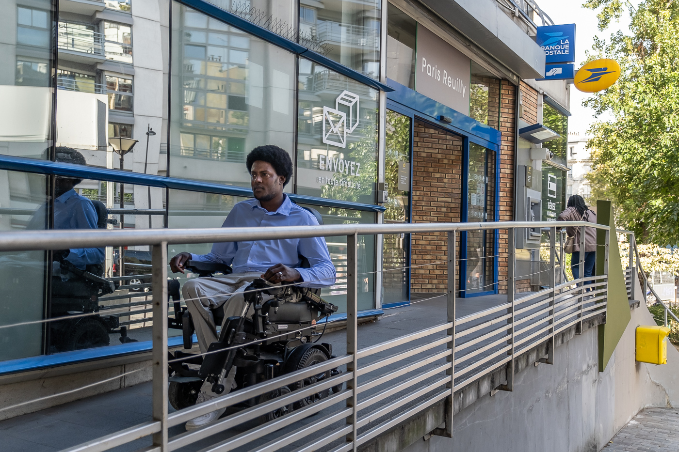 Souleyman Youssouf, habitant du 12e arrondissement, chemine avec son fauteuil roulant électrique dans le Quartier d'accessibilité augmentée du 12e arrondissement