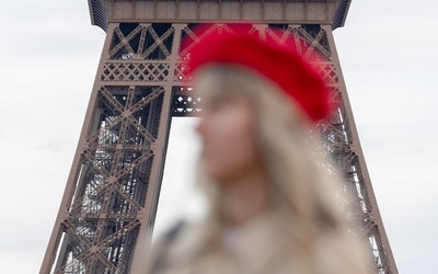 Touriste au béret rouge devant la Tour Eiffel.