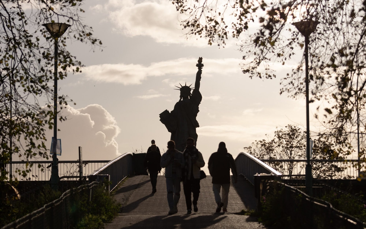 Promeneurs sur l'île aux Cygnes avec la statue de la Liberté en arrière plan (15ème).