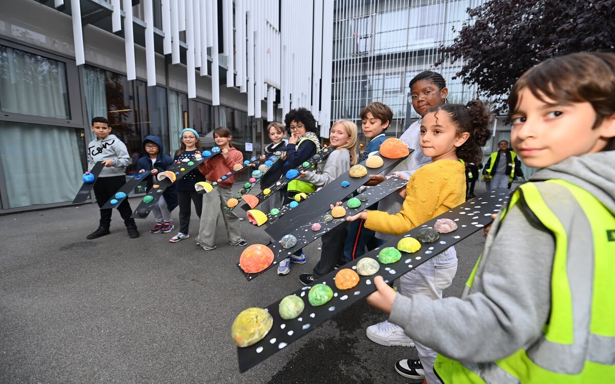 Des enfants montrent les maquettes de systèmes planétaires qu'ils ont fabriqué pendant un atelier d'"Espace dans ma ville"