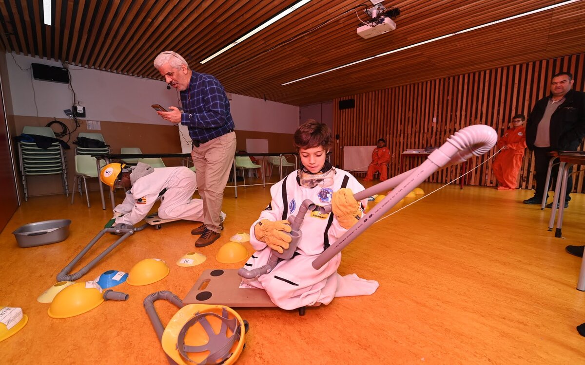 Un enfant habillé en combinaison participe à un jeu de réparation d'une station spatiale