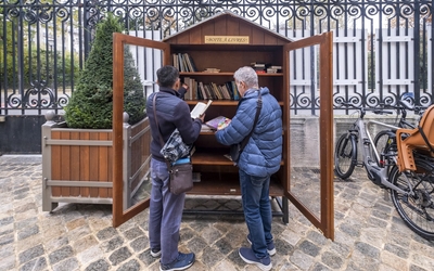 Deux Parisiens font leur choix devant une des nombreuses boîtes à livres de Paris