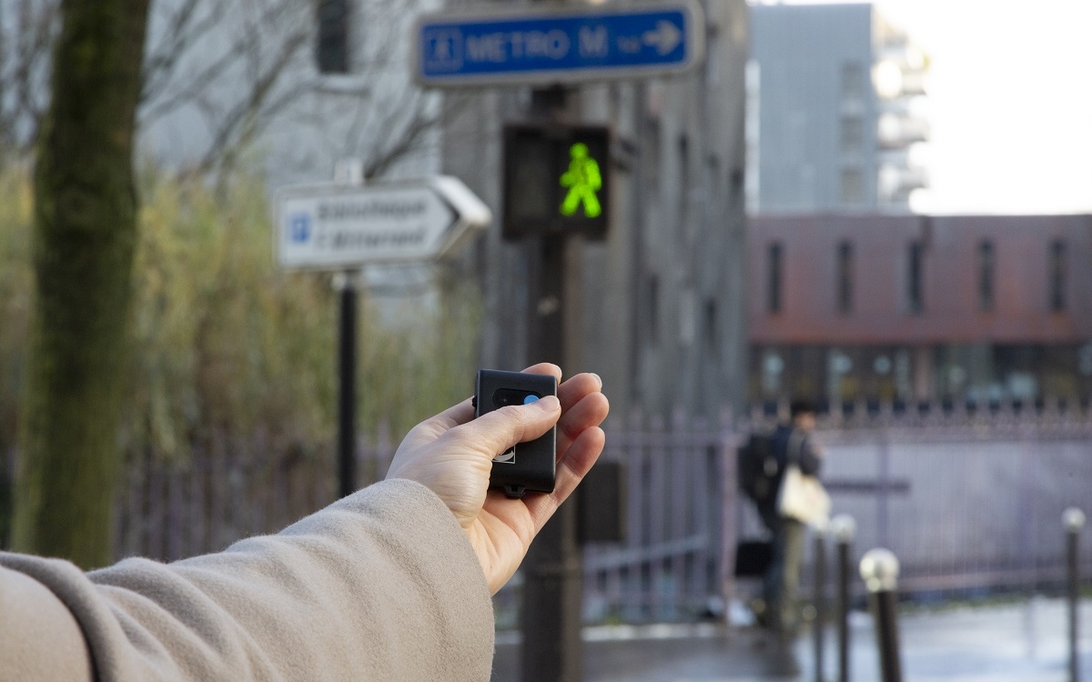 Photo de l'utilisation d'une télécommande activant le dispositif sonore d'un feu de signalisation