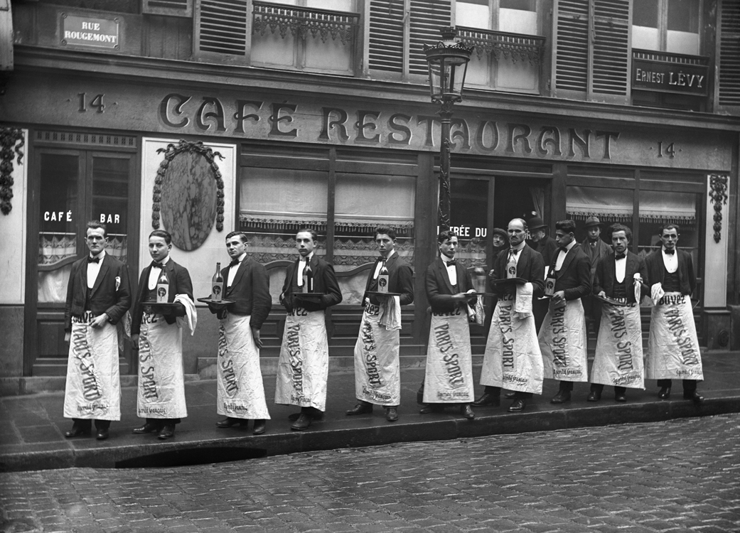 Garçons de café prêts pour leur course annuelle. Paris, rue Rougemont, vers 1920.
