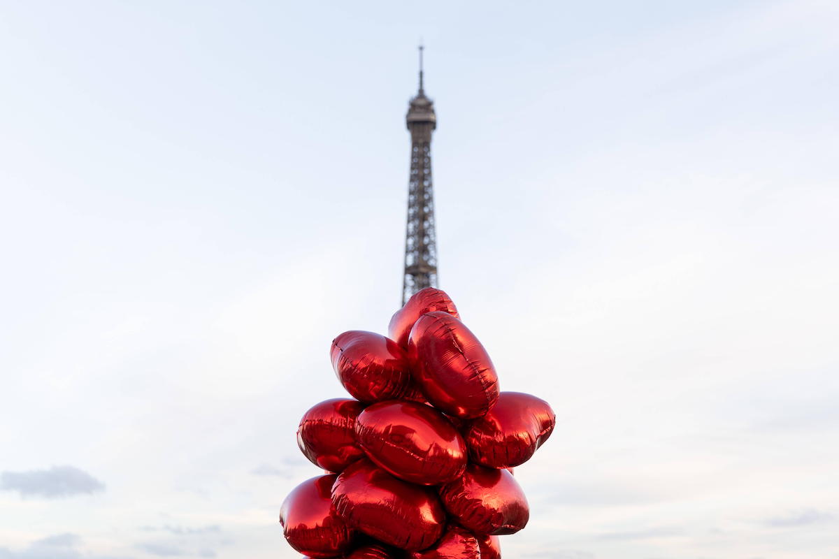 Des ballons rouges en forme de cœurs devant la Tour Eiffel