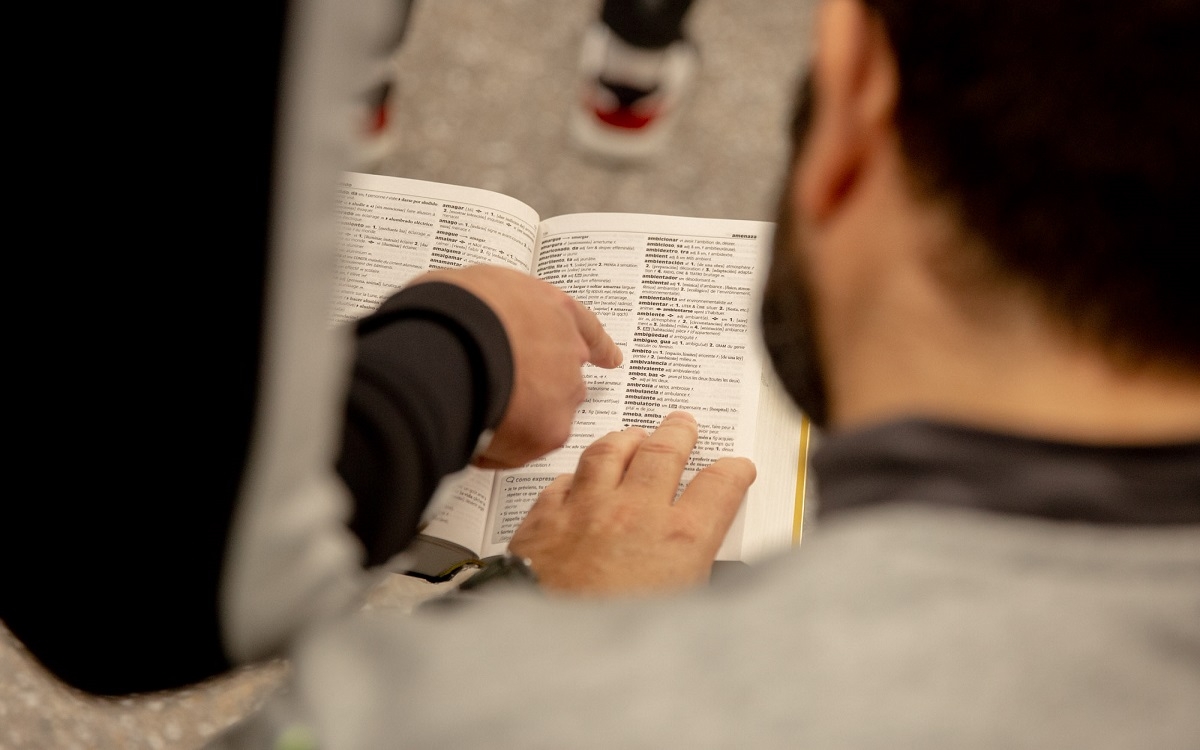 Deux participants de l'atelier regardant un dictionnaire français-espagnol