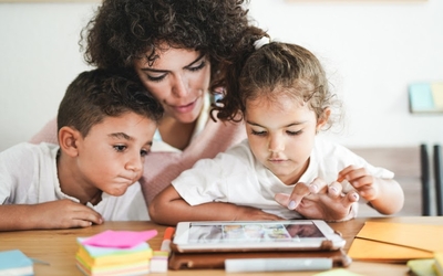 Maman avec ses deux enfants en  train de regarder une tablette