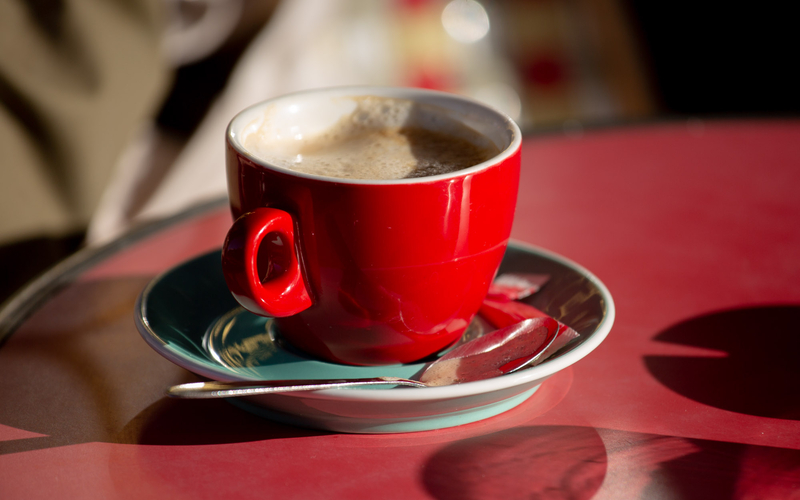 Tasse à café rouge sur une table de bistrot. 