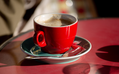 Tasse à café rouge sur une table de bistrot. 