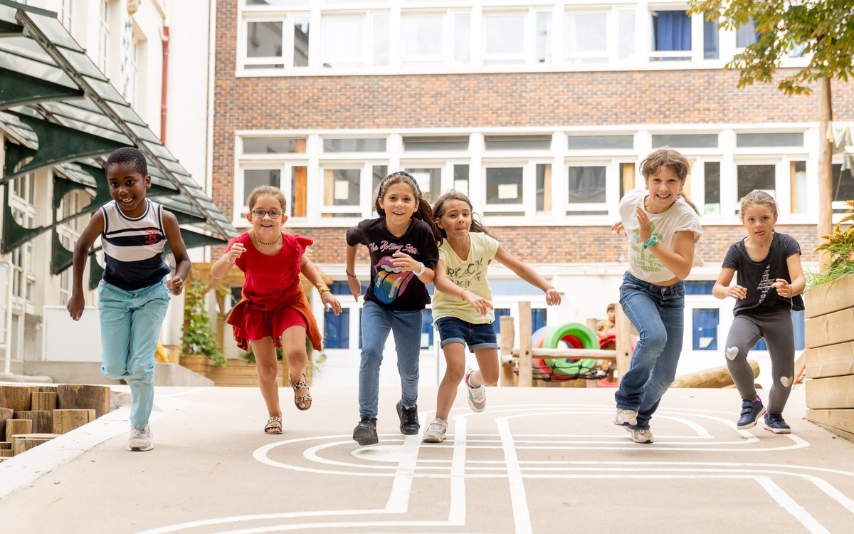Groupe d'enfants effectuant une course dans une cour d'école. 