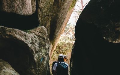 Une randonneuse dans un passage escarpé entre rochers