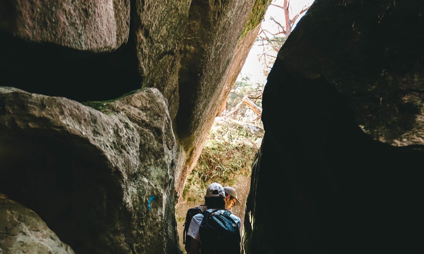 Une randonneuse dans un passage escarpé entre rochers