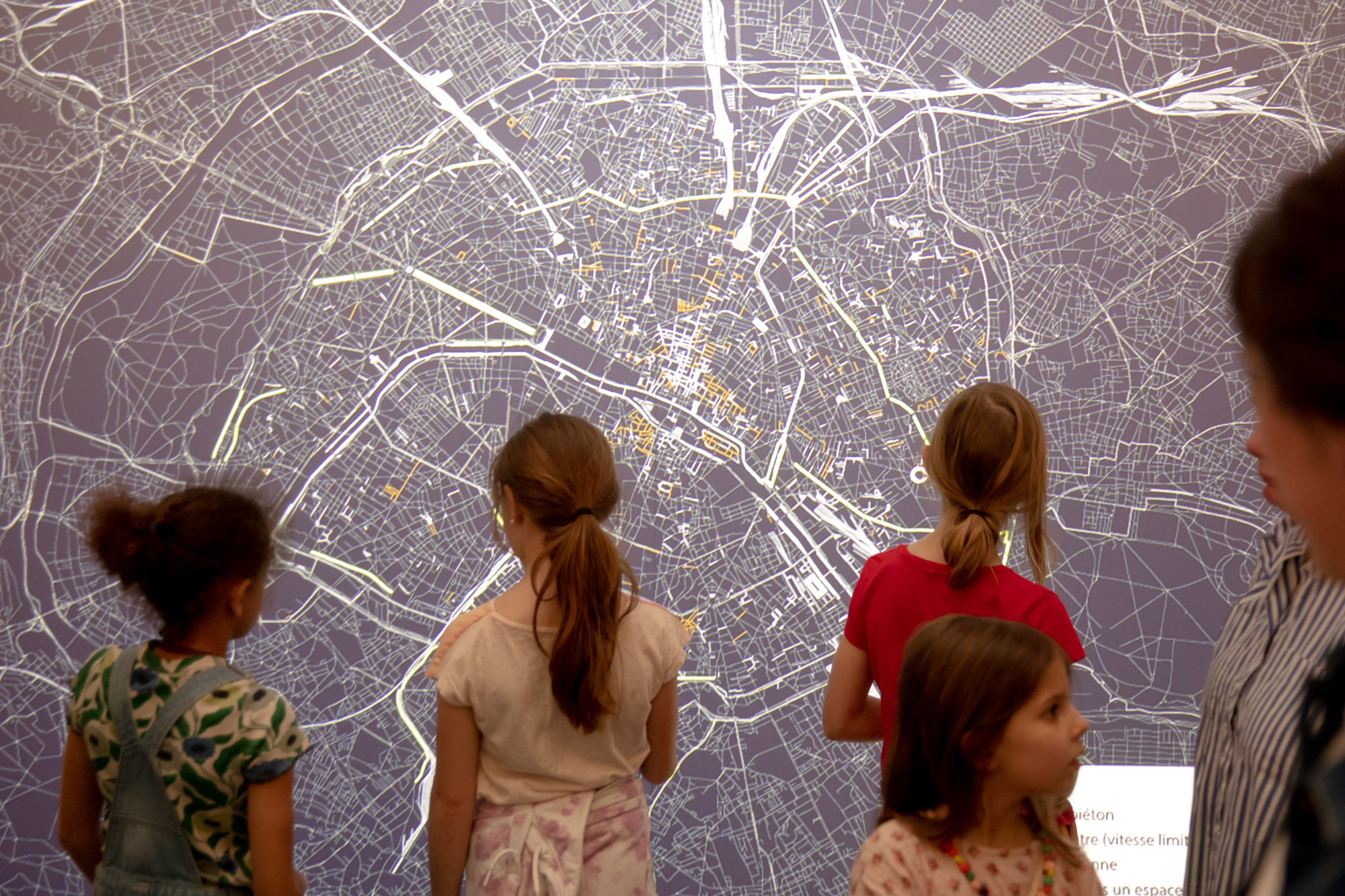 Des visiteurs devant une carte de Paris durant le vernissage de l’exposition « Paris ! »