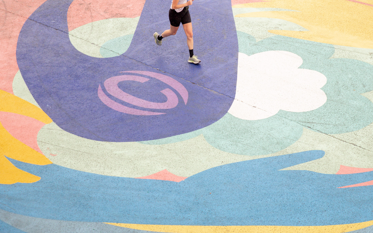 Un coureur foulant le sol de la fresque ASICS sur le quai de Seine. 